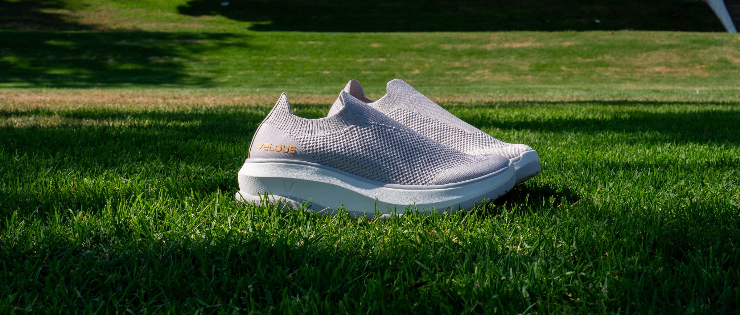 White slip-on shoes on a grassy surface